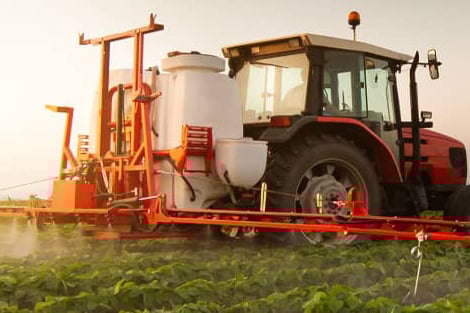Tractor spraying soybean field at spring
